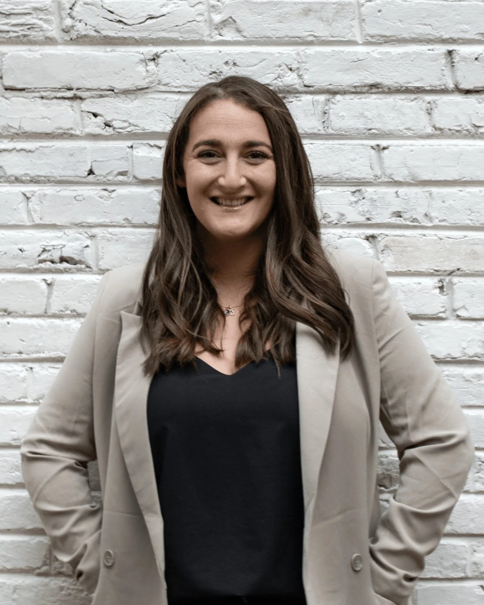 Lindsay Tiell, LICSW, LCSW-C, smiling in front of a white brick wall